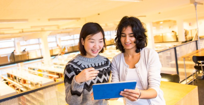 zwei Bibliotheksbesucher mit ihrem Tablet im Lesesaal