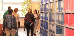 A librarian shows a group of students the library