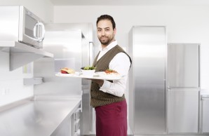 Junger Mann mit Tablett in der Hand