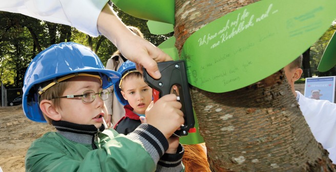 Kita-Kind Julius hat seine Wünsche für die neue Kinderklinik an den Wunschbaum geheftet