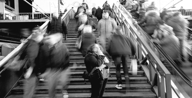 Frau steht verloren im Bahnhof