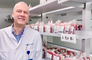 Dr. Peine, Leiter der Transfusionsmedizin, im Portrait vor Blutkonserven von Spender:innen