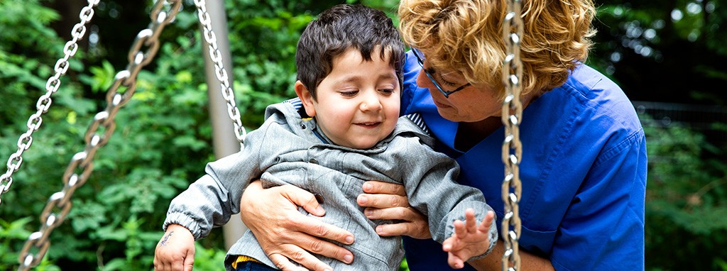 Kind beim Spielen mit einer Kinderkrankenschwster